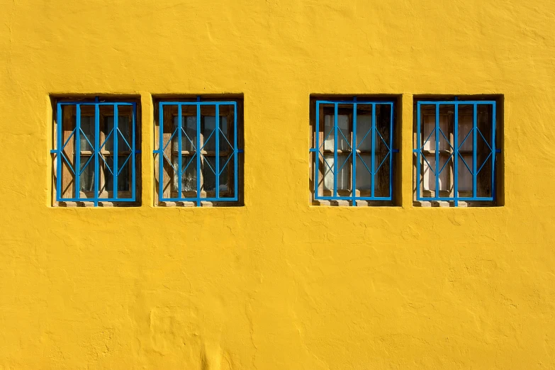 blue and white window frames on yellow building