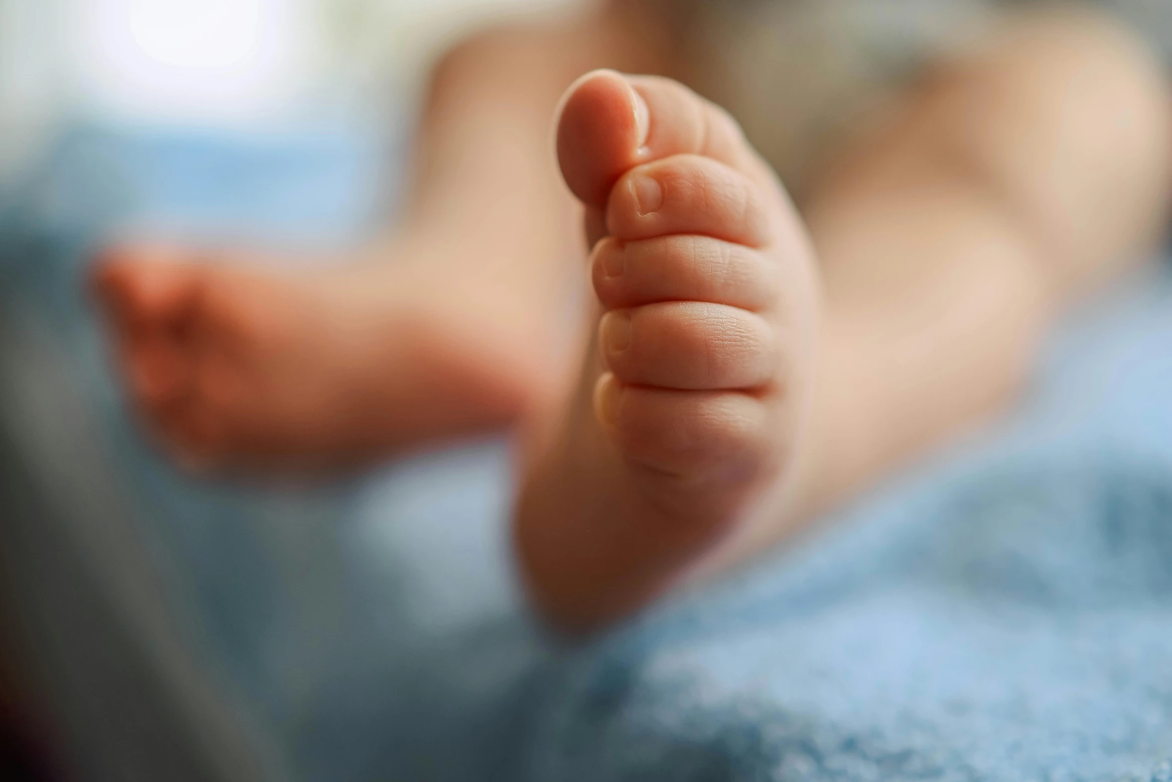 an infant feet in the air with one foot up