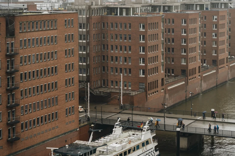 there are people walking on a walkway over a river