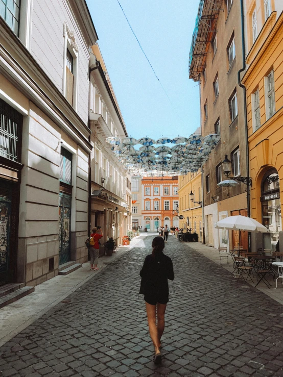 a woman walking down the middle of an empty street