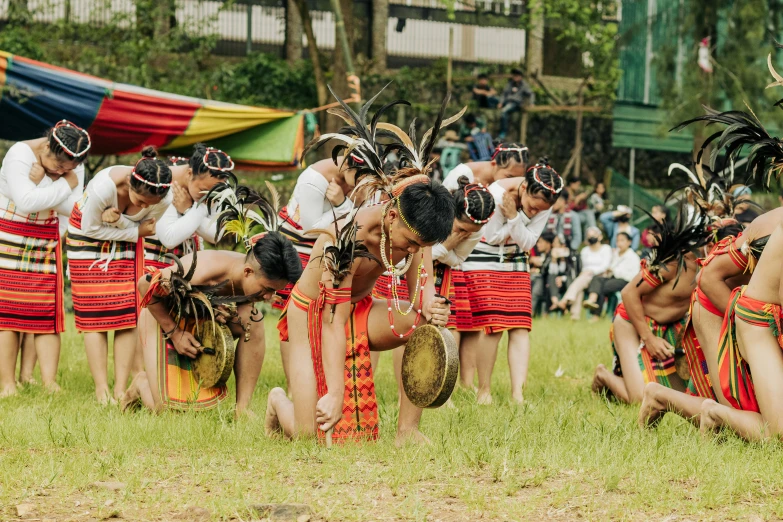 several men in elaborate costumes holding drums while standing around