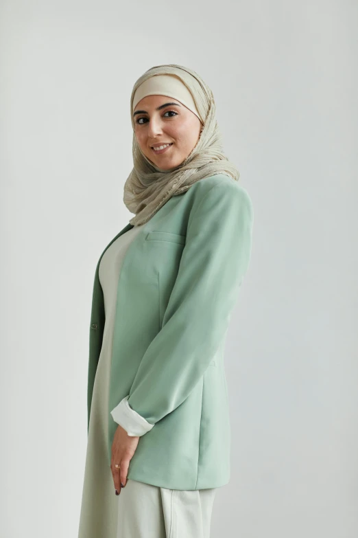 an attractive young woman poses in a green coat