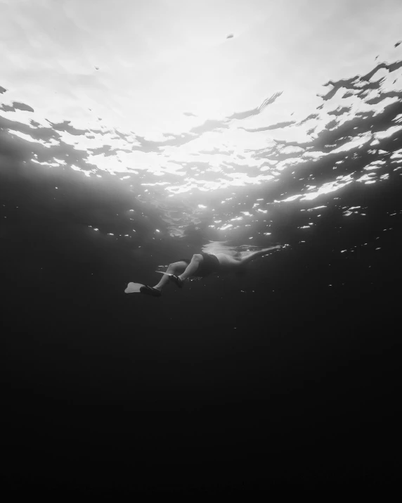 a person swims under water in the ocean