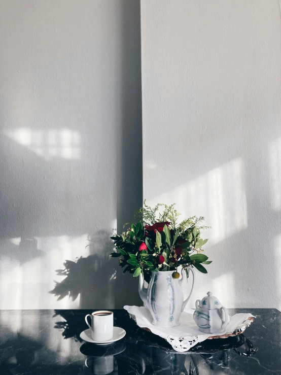 there is a flower in the vase on a tray near a teapot