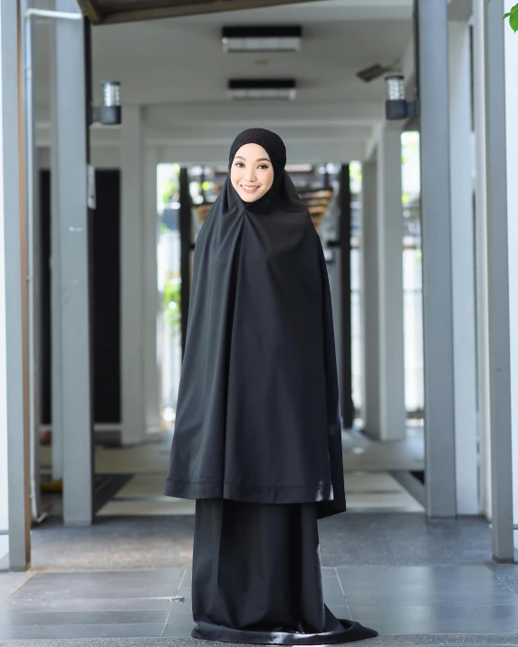 the muslim woman wearing a black veil is standing alone