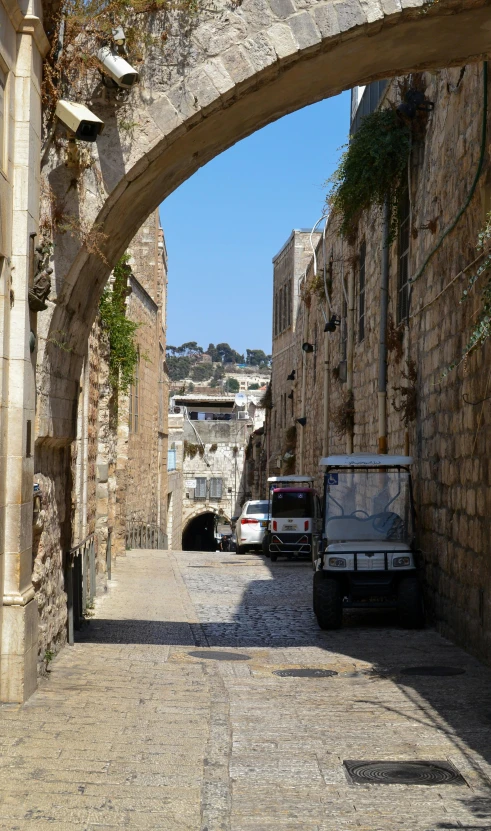 a narrow stone road next to old brick buildings