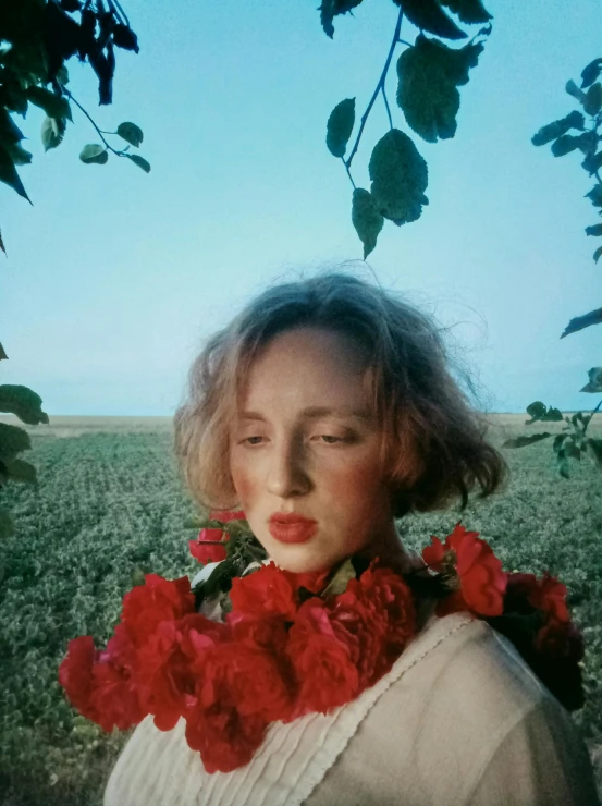 a woman wearing a flowered neck tie in front of green grass