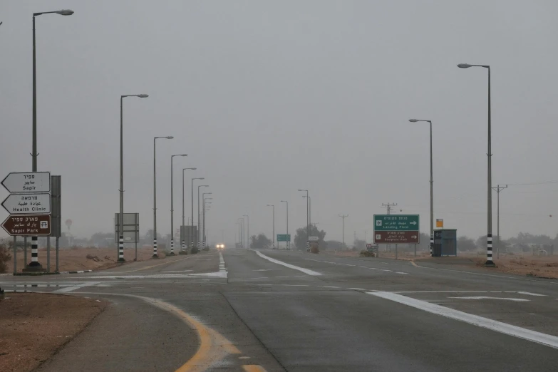 traffic lights on a road with snow falling from above