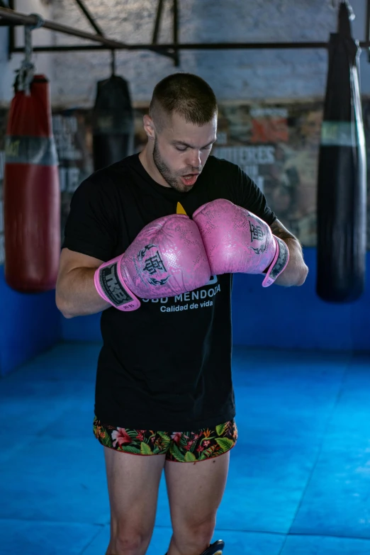 a man in a black shirt holding up boxing gloves