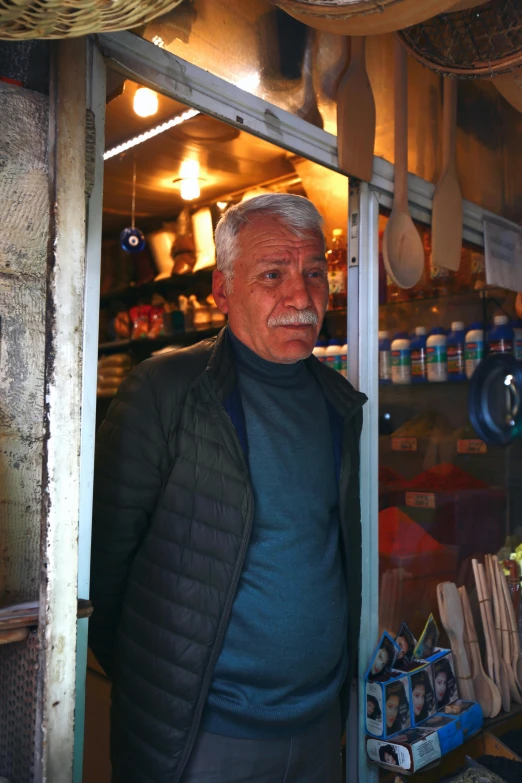 a man standing outside of a store with pots and pans on display