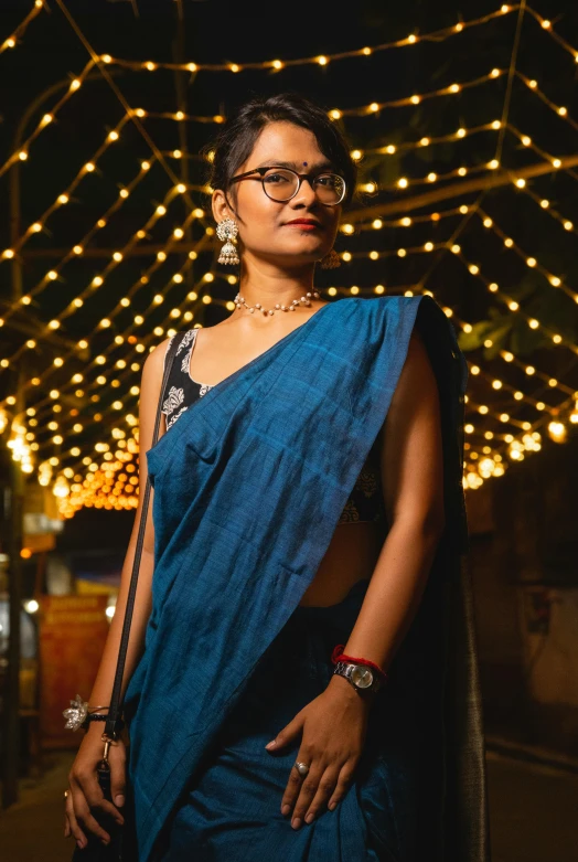 woman in sari standing in a dimly lit area