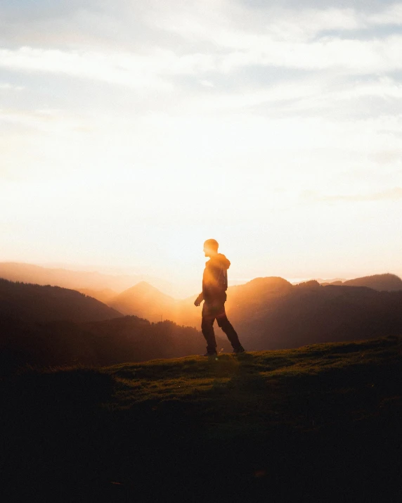 a person standing on top of a lush green hill