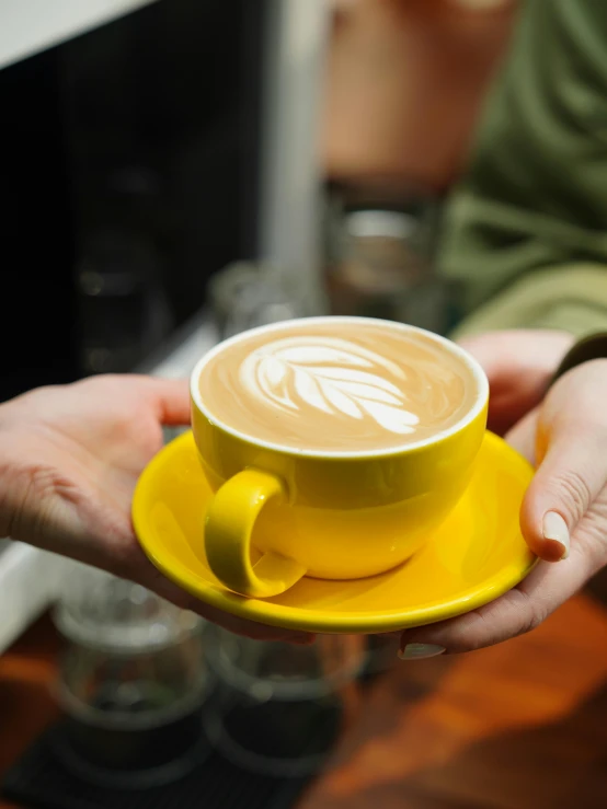 two people are holding a cup and saucer