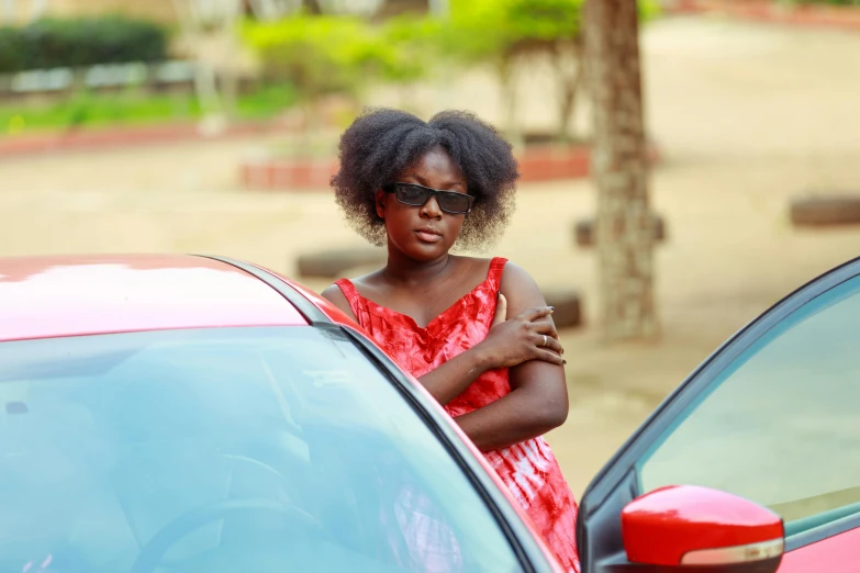 a lady standing by her car outside of a house