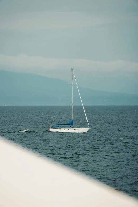 a sailboat sitting on the water at dusk