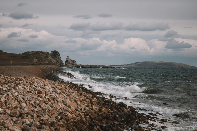 waves crashing onto the shore, along with a rocky shoreline