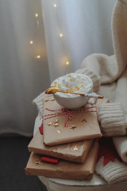 a bowl of white frosted on top of christmas gifts