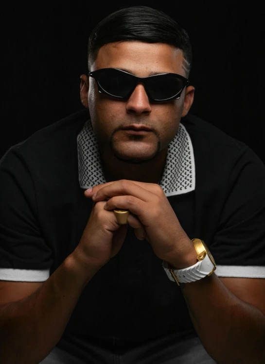 a man with gold ring on his finger with sunglasses over his eyes