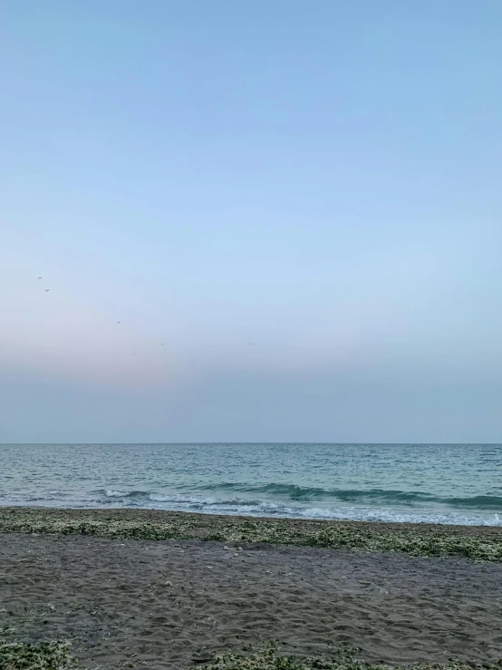 a man walking on the beach carrying an umbrella