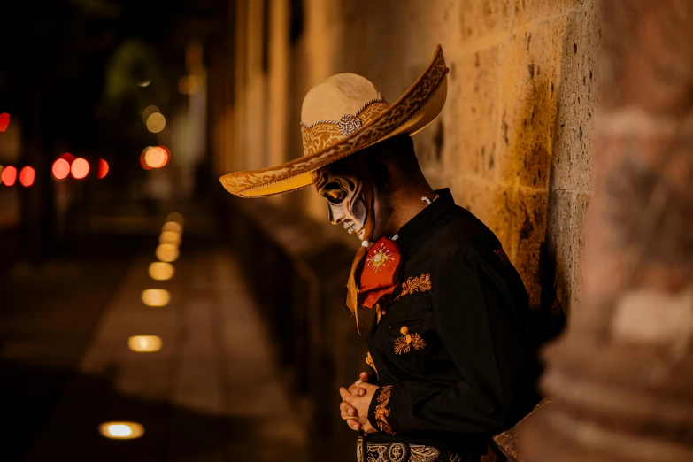 a man wearing a mexican outfit and hat on the street