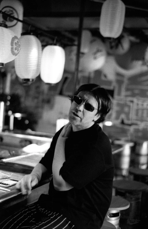 a man sitting at a bar and wearing sunglasses