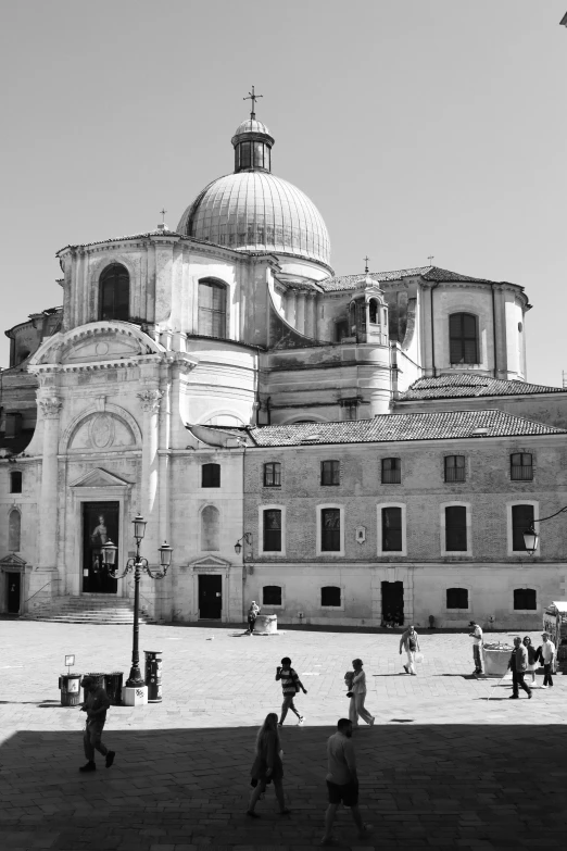 people walk around in front of an old church