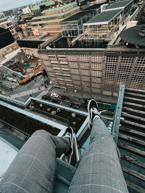 the feet of a person standing on top of a building