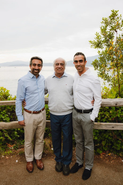 three men pose for a po while posing for a picture