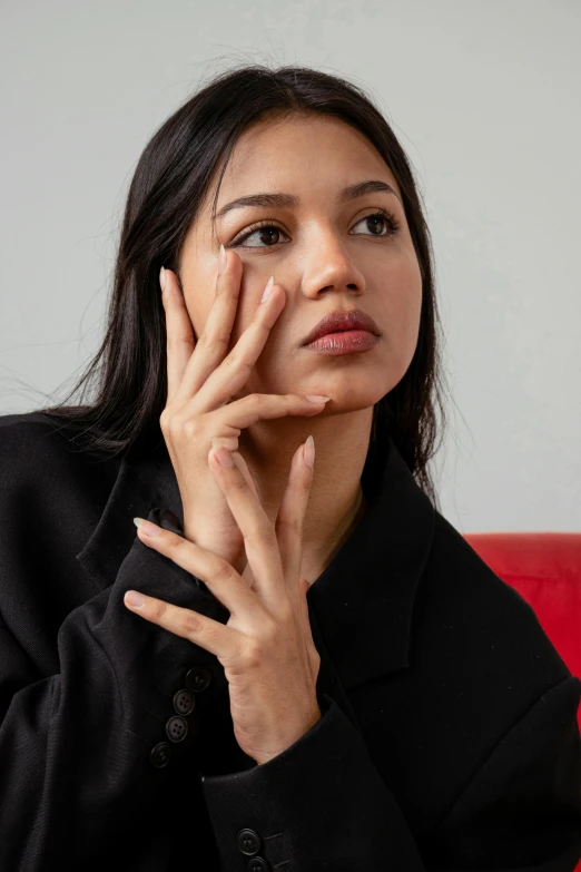 the woman looks surprised while sitting on a red chair