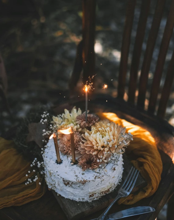 a cake with lit candles sitting on a wooden table