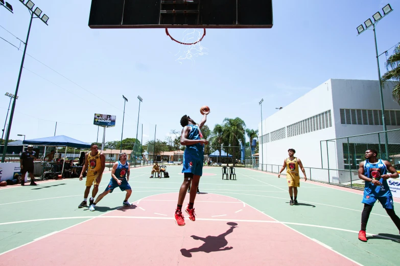 a basketball game with players in blue uniforms jumping for the ball