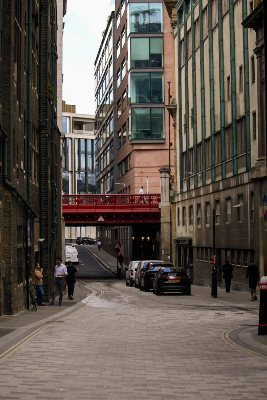 a small red bridge spans over an urban street