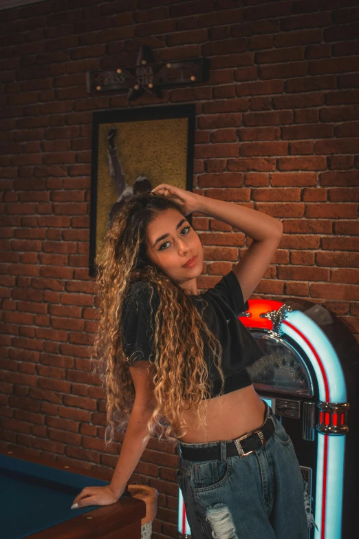 an attractive woman leaning on a red and white striped bench with a brick wall in the background