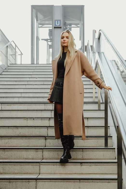a woman is standing on the stairs of a staircase
