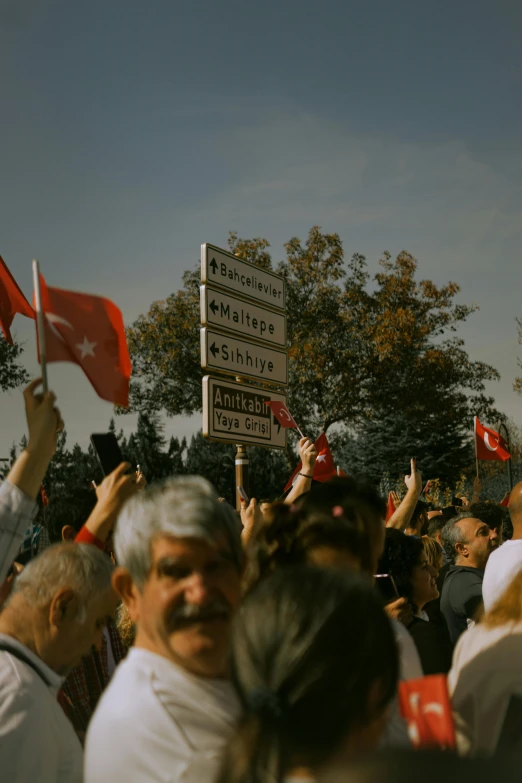 an image of a group of people holding up red and white flags