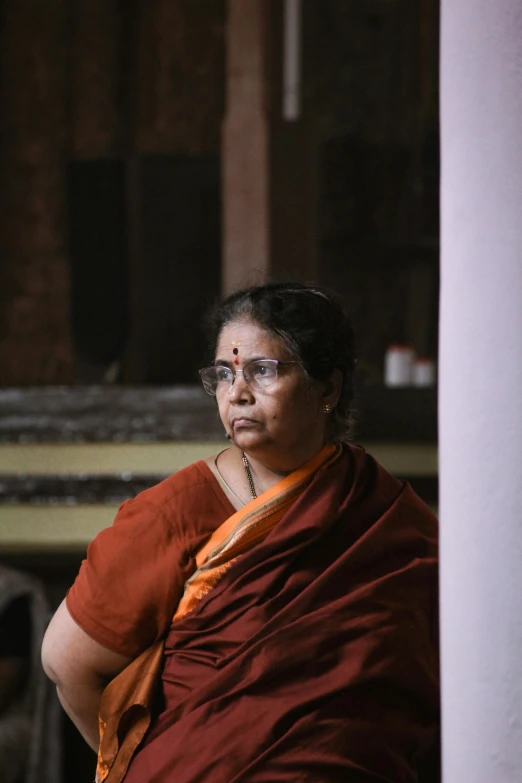 a woman wearing a maroon robe and holding a piece of cloth