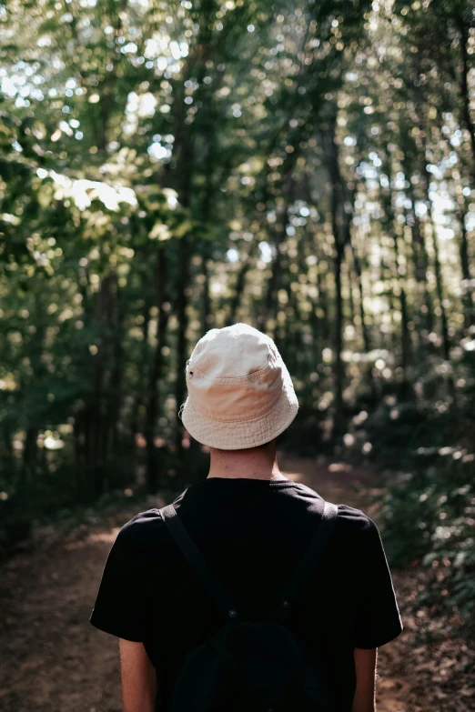 a young person standing on a trail in a forest