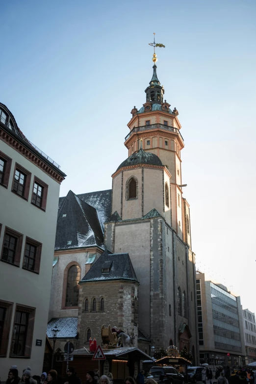 people standing around looking at old buildings with many spires