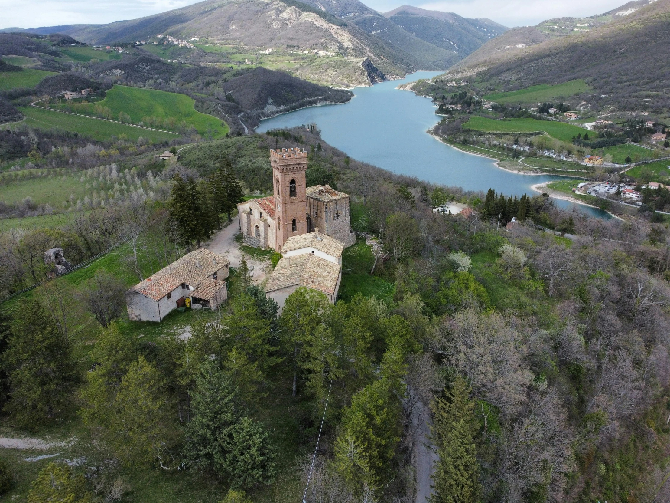 an aerial view of a castle surrounded by green hills and trees