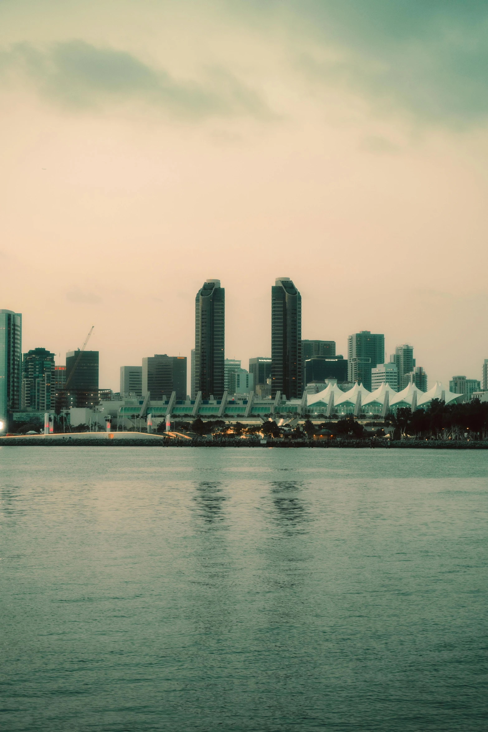 a large city skyline sits above the water in front of tall buildings