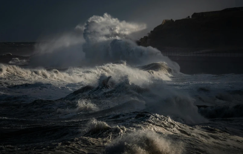 a crashing wave crashes on a rocky beach