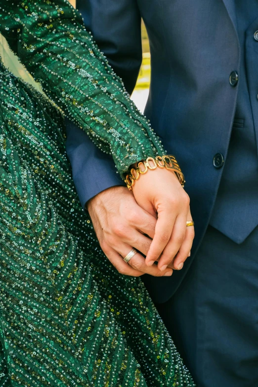 a man and woman dressed in green holding hands