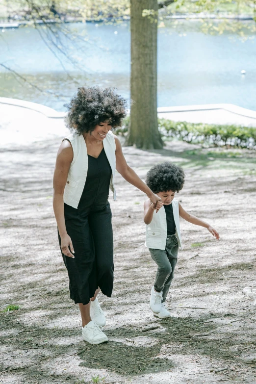 there is a young woman walking next to a small boy