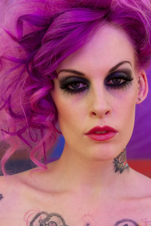 woman with short purple hair and tattoos wearing black dress