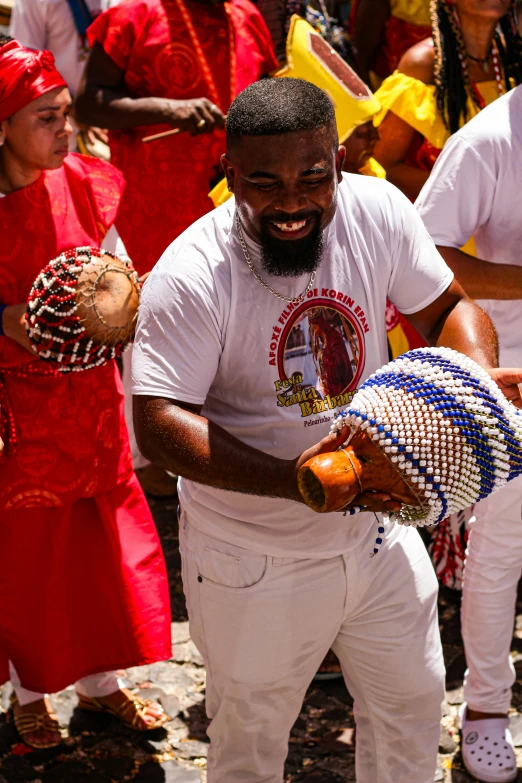 a man in a white t - shirt holding some ball