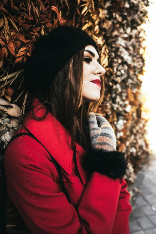 a woman wearing a hat and coat is posing