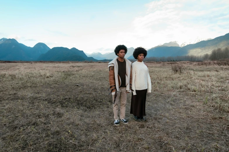 a couple of people standing in an open field