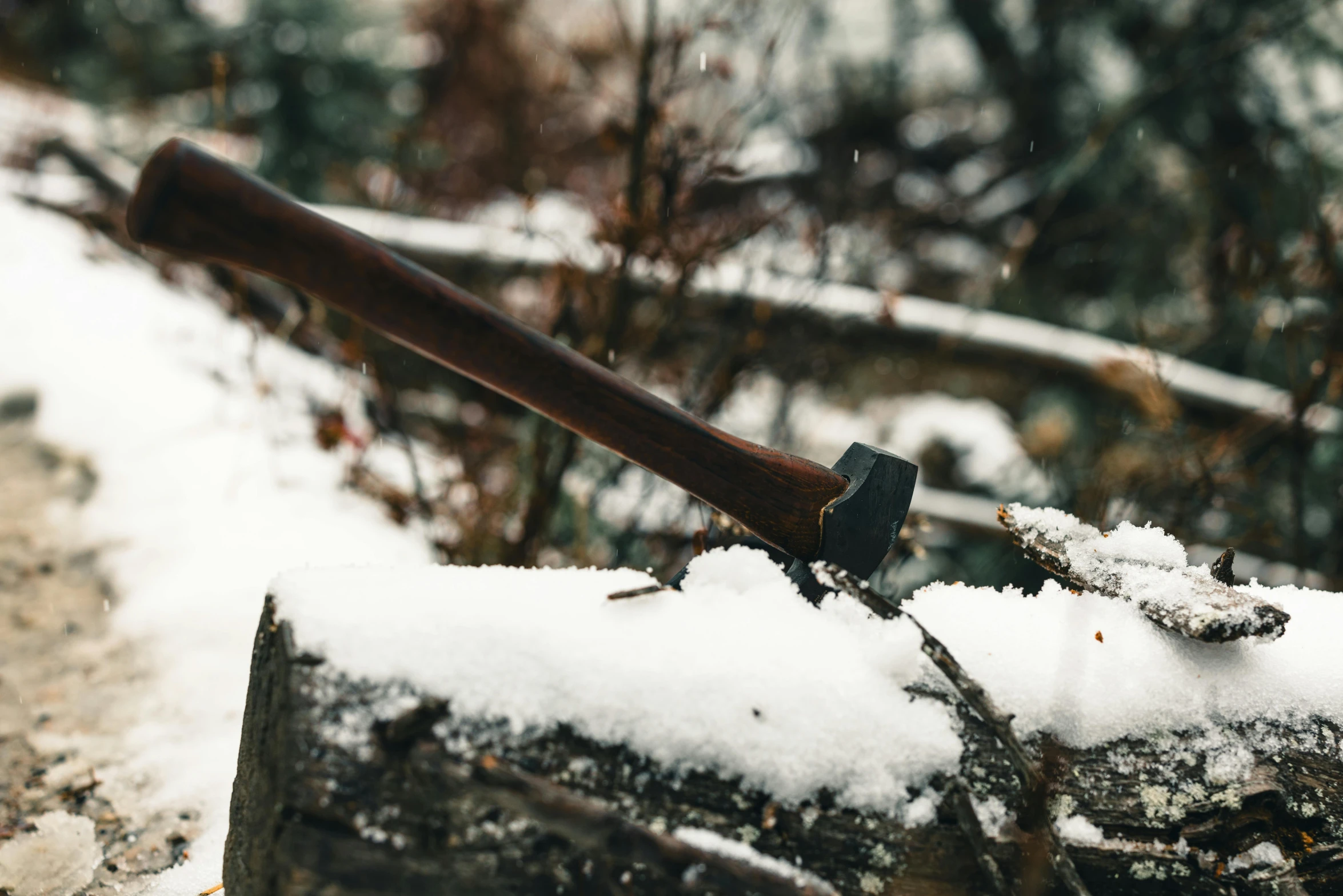 a hammer sitting on top of snow covered log