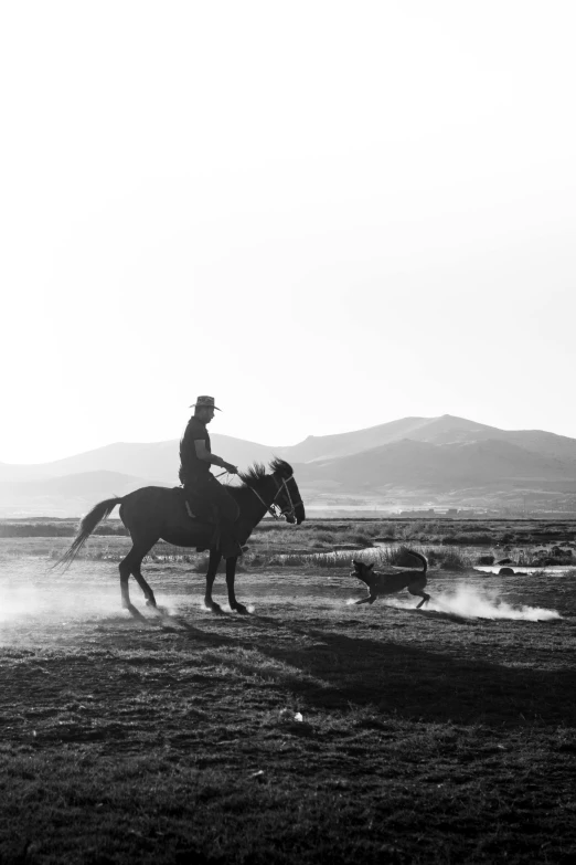 a man on horseback rides across a dusty plain