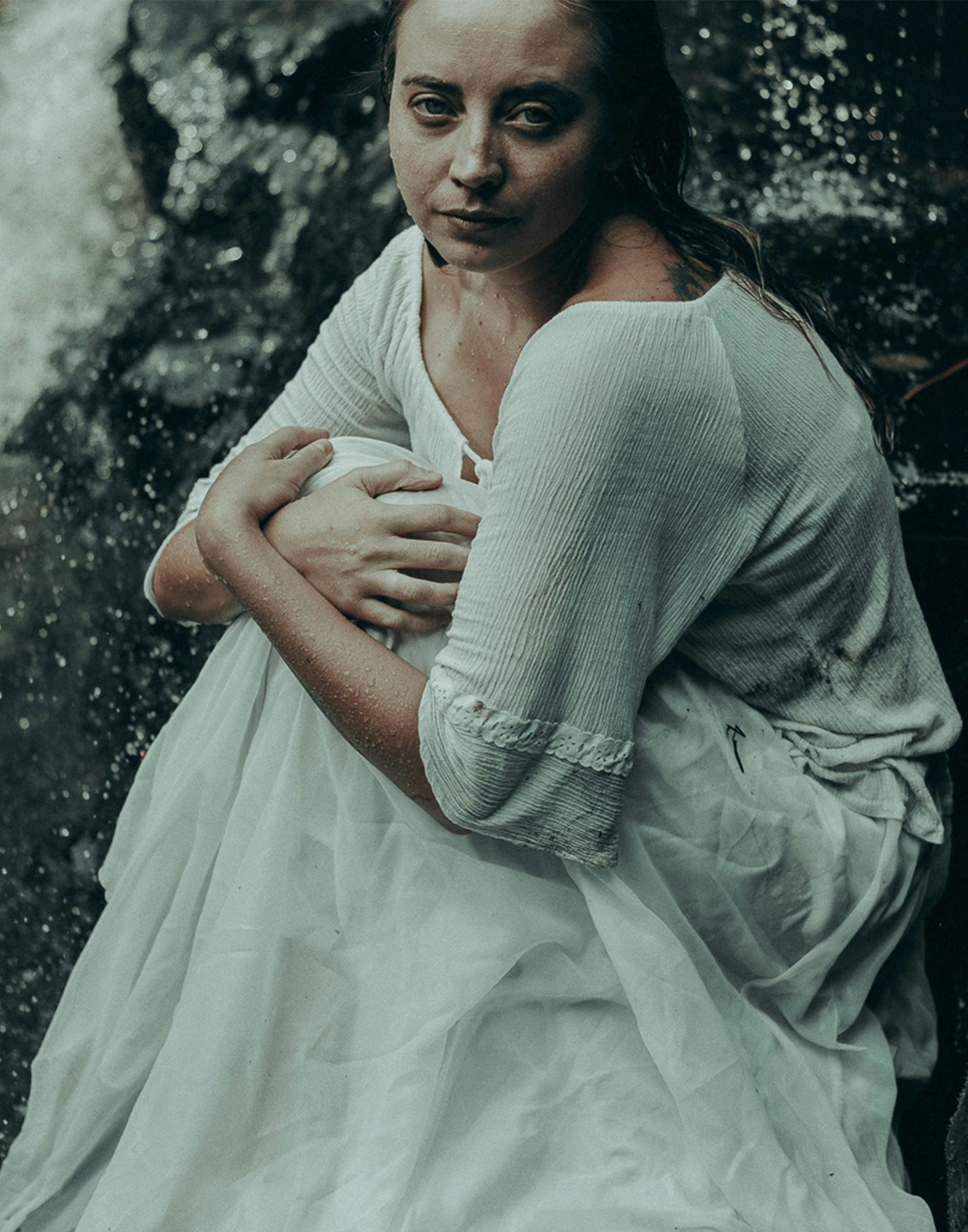 an image of a woman sitting near a waterfall